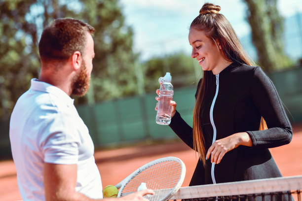 coppia di tennis discutendo la loro partita in seguito - tennis court love victory foto e immagini stock