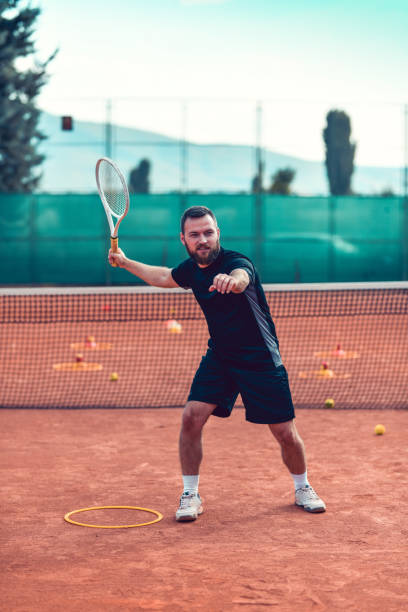 istock Handsome Tennis Player Hitting Ball With Full Force During Match 1277351055