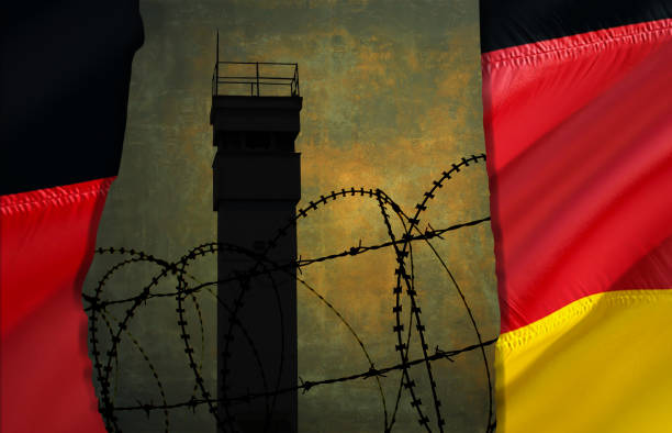 abbildung eines wachturms mit deutscher flagge als wand hinter stacheldraht - tag der deutschen einheit stock-fotos und bilder