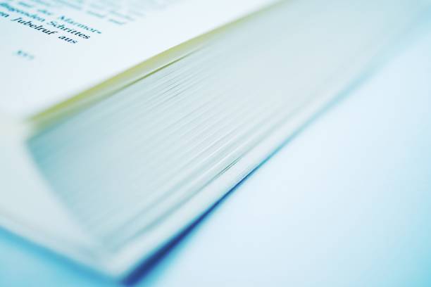 istock Text on the pages of an open book, extreme close-up - Open book side view 1277353423