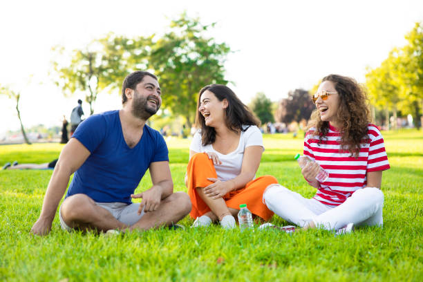 istock Three friends sitting on the grass in the park 1277354517