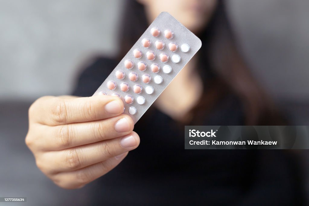 Women carry birth control pills, focus Hand Birth Control Pill Stock Photo