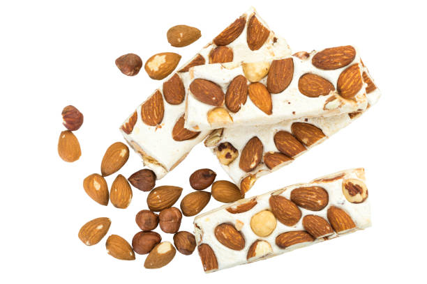 Turron blocks arranged with almonds and hazelnuts , isolated on white background, top view,