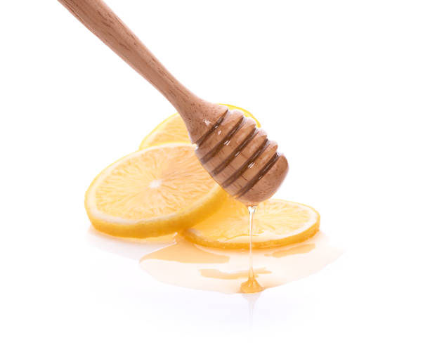 istock Honey dripping on fresh lemon isolated white background 1277355849