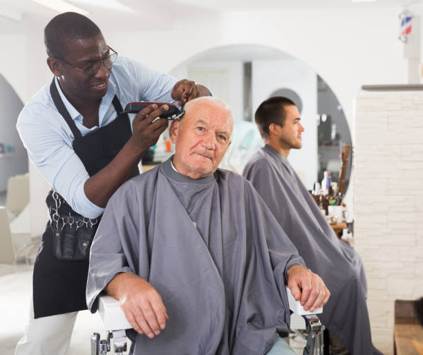istock Elderly man getting haircutting from African barber 1277357450