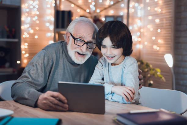 istock Cheerful grandfather with a grandson sits at table 1277357598