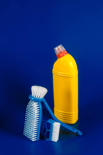 istock yellow Bottle with detergent powder and brushes on blue background, space for text 1277359147