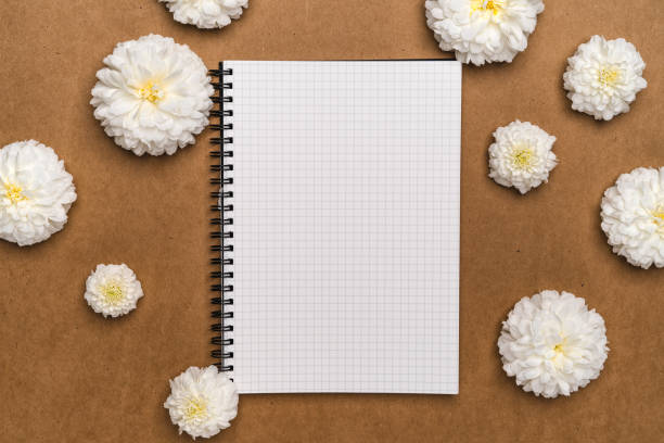 istock A notebook and white flowers on brown paper 1277359273