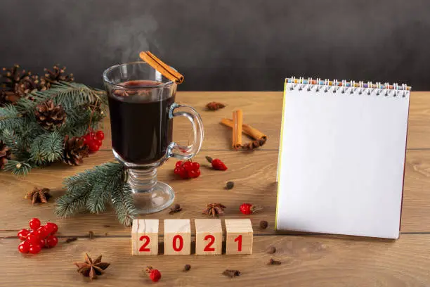 Photo of Hot mulled wine, Christmas tree, decoration, cones, to do list. 2021 on wooden cubes. blank, Empty notebook. Writing plans for the new year.