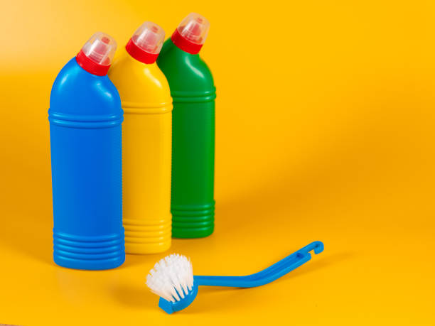 istock Bottles with detergent and cleaning tools on yellow background 1277360196