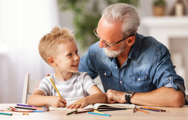istock Cheerful boy drawing with grandfather 1277361583