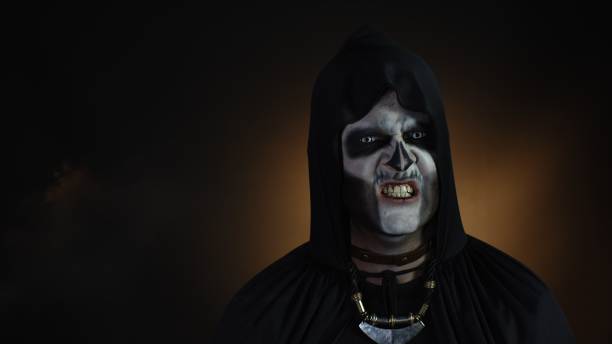 istock Sinister man with Halloween skeleton makeup making faces, looking at camera, trying to scare 1277362181