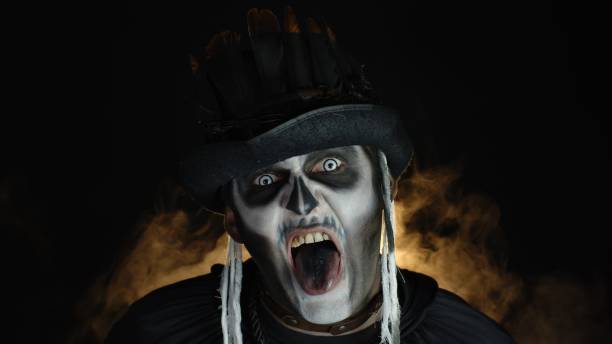 istock Creepy, crazy man with skeleton makeup. Guy making angry faces, shaking head, showing tongue 1277362553