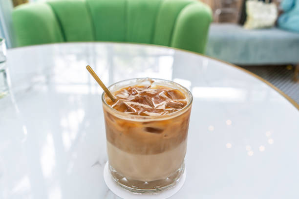 istock Ice coffee in a tall glass with milk poured over 1277362861