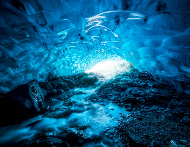 eingang einer kristallblauen eishöhle mit unterirdischem fluss im vatnajokull-gletscher, island - ice crystal winter nature ice stock-fotos und bilder