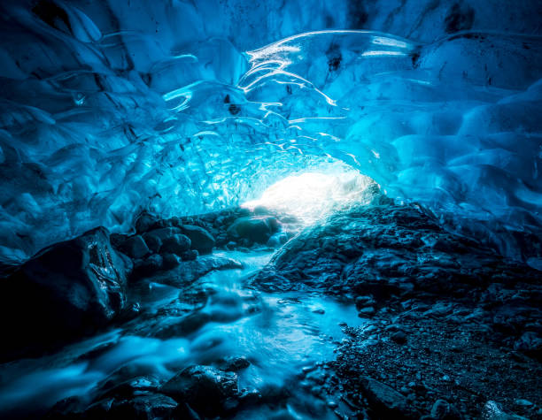 Entrance of an crystal blue ice cave with underground river inside Vatnajokull glacier, Iceland stock photo