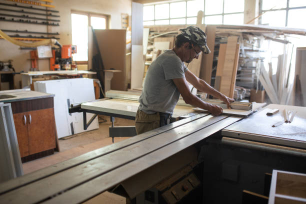 istock Carpenter using table saw in workshop of woodworking company 1277368278