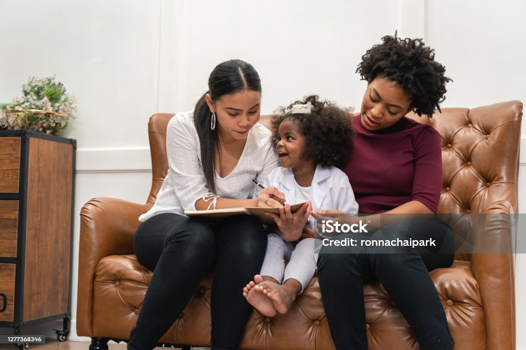 LGBT diversity Lesbian Couple Moments Happiness with her african girl laughing and drawing picture, LGBT lifestyle. Gay Person Stock Photo