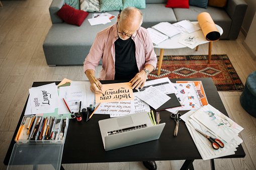 Artista senior de caligrafía en su oficina en casa creando photo