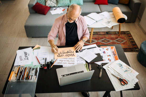 Calligraphy senior artist in his home office creating