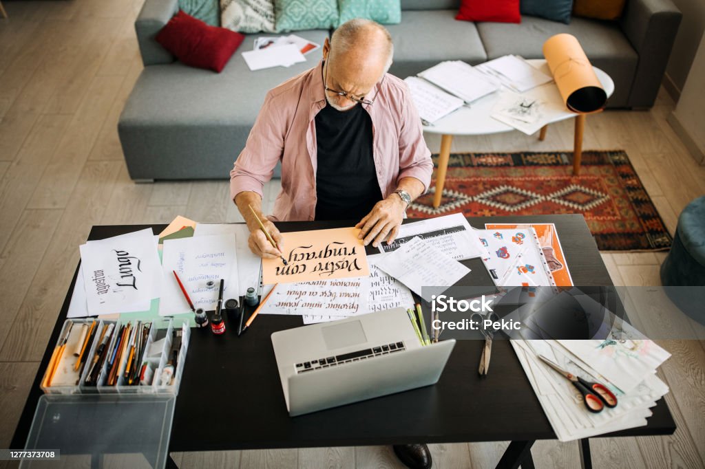 Calligraphy senior artist in his home office creating Calligraphy Stock Photo