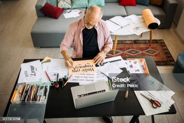 Calligraphy Senior Artist In His Home Office Creating Stock Photo - Download Image Now