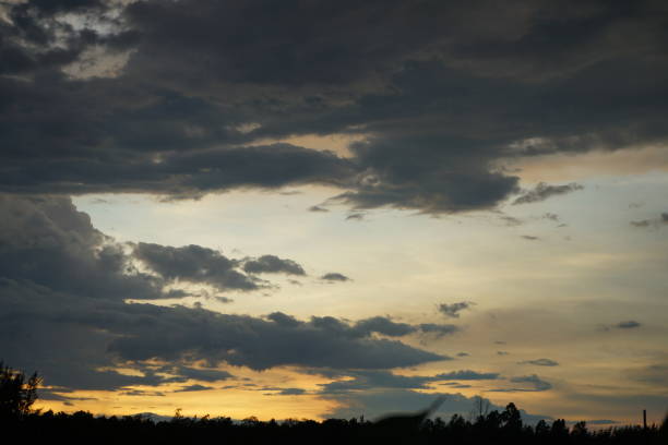 istock sunset over the clouds or Golden sky, the sun sets, gray clouds float, before the rain, there are trees in front. 1277375826