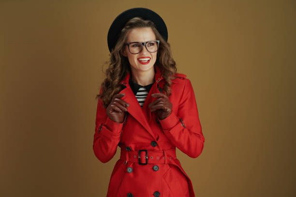 istock smiling modern woman in coat and beret on brown background 1277378604