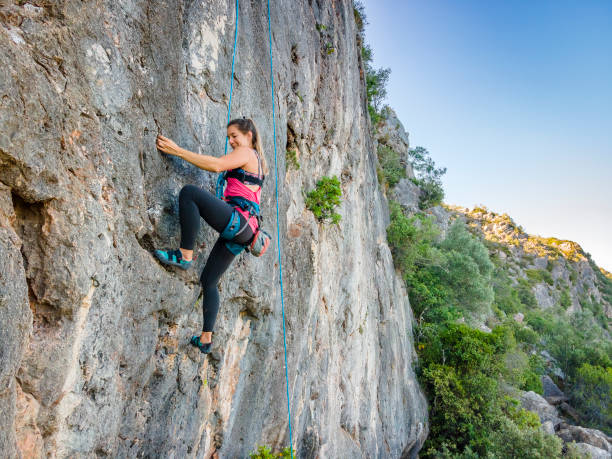 istock A woman in harness climbing a steep rock 1277384000