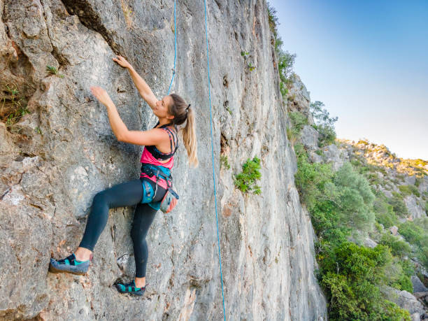 istock A woman in harness climbing a steep rock 1277384012