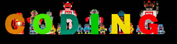 istock retro tin robot toys hold up the word CODING  black 1277385475