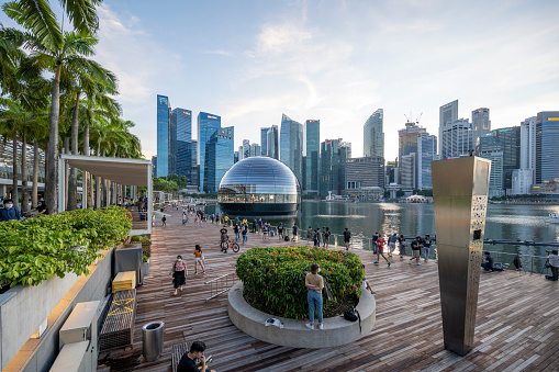 Apple opened the worlds first floating Apple Store at the Marina Bay in Singapore at the time of this shoot, 10th September, 2020. After a few days it has already become a Singapore landmark. Here the store seen at sunset. Behind the store the skyline of the Singapore financial district.
