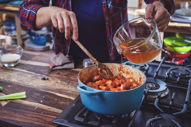 鋳鉄鍋でのケイジャンスタイルのチキン、エビ、ソーセージジャンバラヤの準備 - prepared shrimp ストックフォトと画像