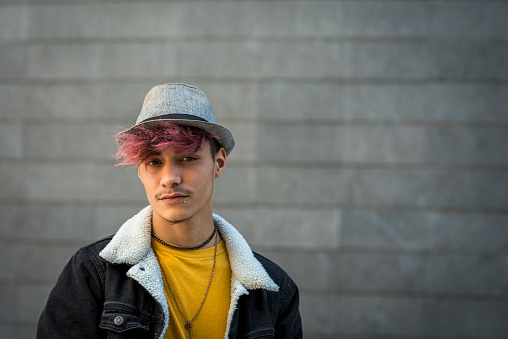Retrato adolescente alternativo mirando a la cámara - pelo de diversidad violeta y fondo urbano gris - ropa de moda con gente joven al aire libre - imagen del espacio de copia photo