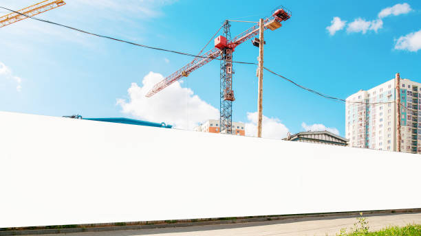 long hoarding with empty space for mock up on construction site red crane and blue sky background - greed imagens e fotografias de stock