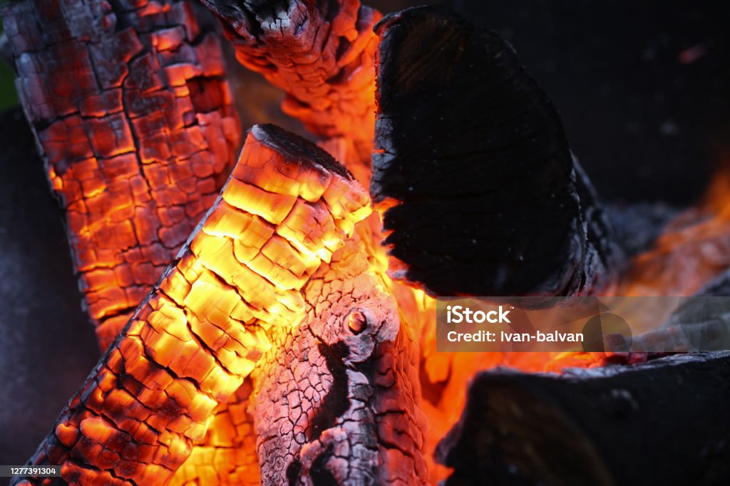 Bright colour of sticks Close-up of actively smoldering embers. Red live coals in burning fire. Bonfire on street. Flame and sparks rise up in air. Outdoors activity and barbecue concept Abstract Stock Photo