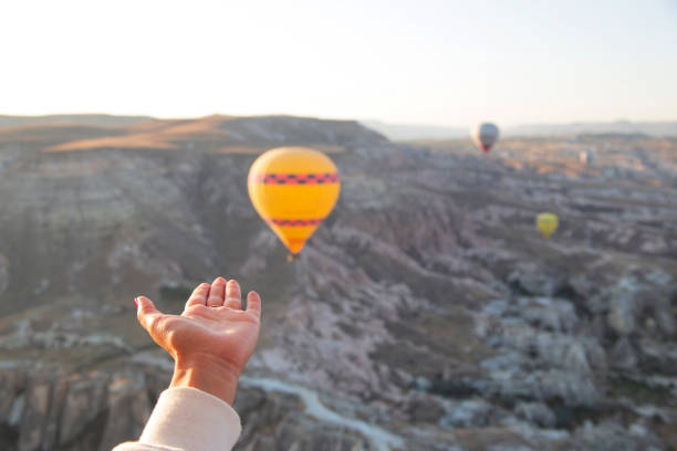 istock Flying balloons in the sky and female hands reaching for them 1277392925
