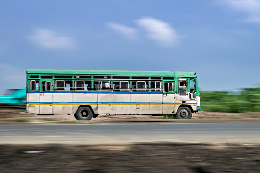 Motion blur image of non air-conditioned intercity bus in Maharashtra, speeding on the street. India.