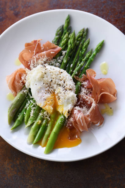 istock Eggs Benedict with parmesan, green asparagus and Parma ham. 1277397673