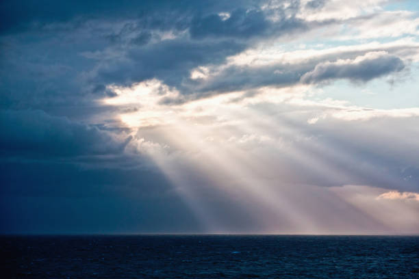 istock Dramatic ethereal sunbeams breaking through clouds over a twilight ocean symbolize spirituality or religion 1277398313