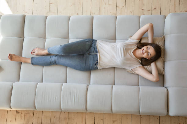 istock Young female lying on sofa at home 1277398399