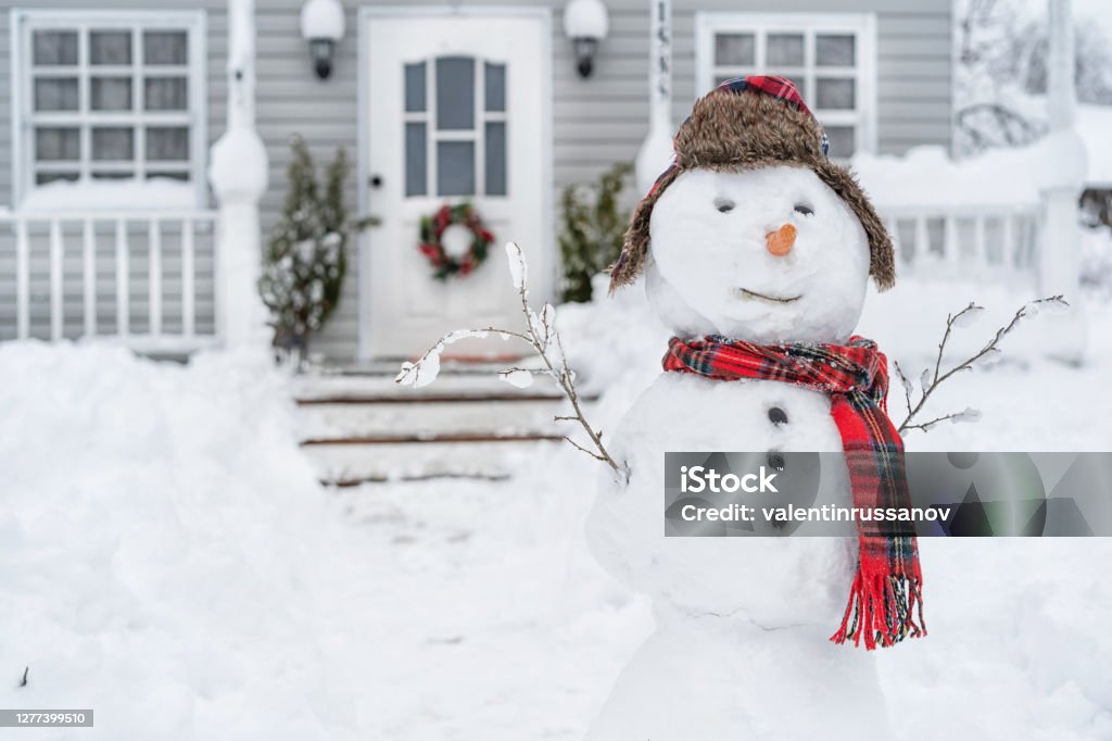 Smiling snowman in front of the house on winter day Winter Stock Photo