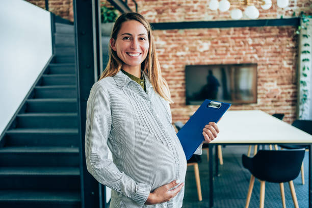 verticale de femme enceinte dans le bureau. - anticipation smiling touching image technique photos et images de collection