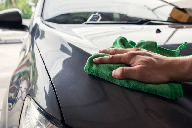 istock Hand man with green microfiber cloth wiping on car hood 1277401583
