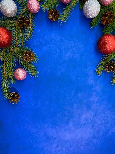 istock Bright Christmas background. Fir branches with pine cones and balls on an abstract blue surface. 1277402544