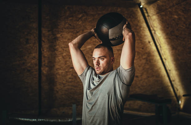 kuvapankkikuvat ja rojaltivapaat kuvat aiheesta urheilullinen mies harjoittelee lääkepallon kanssa kuntosalilla - medicine ball