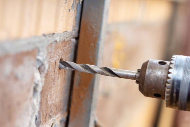 istock Drilling hole in a brick wall close up 1277407670