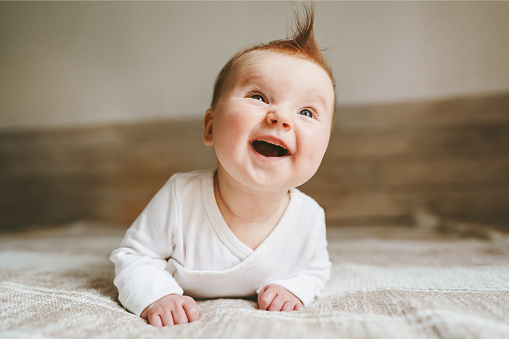 Happy baby crawling in bedroom family lifestyle smiling laughing child 3 month old kid positive emotions
