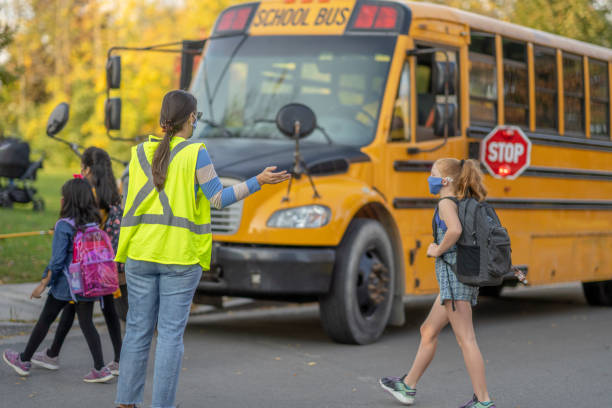 Students walking to the school bus while wearing protective face masks due to COVID-19