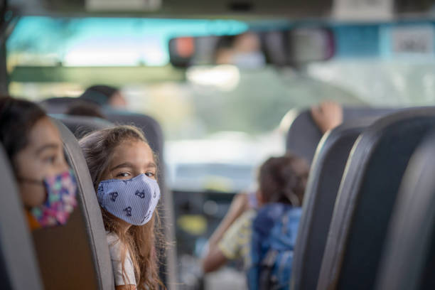 istock Elementary school children wearing masks on a bus 1277409980